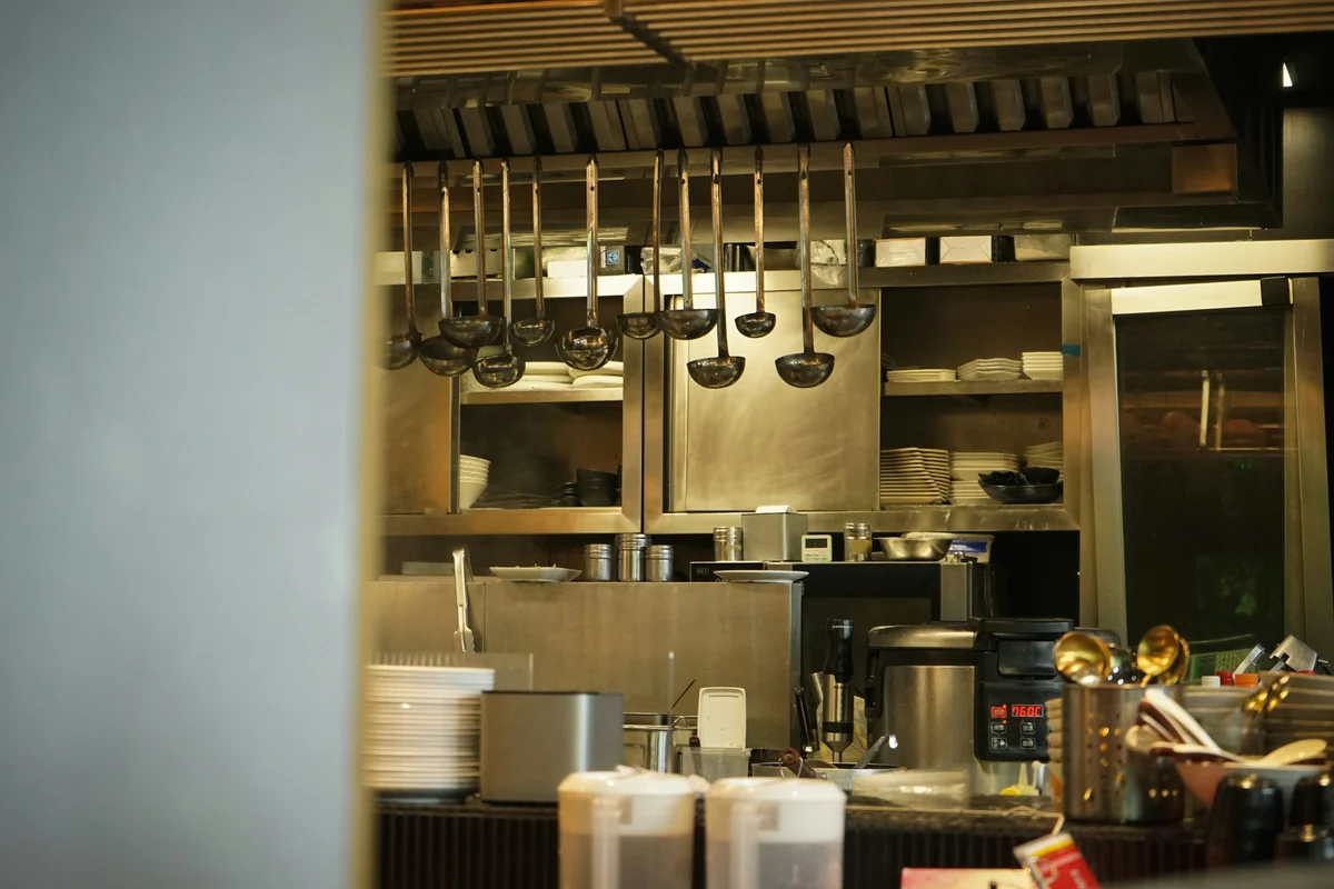Commercial kitchen utensils and cookware hanging in a professional kitchen