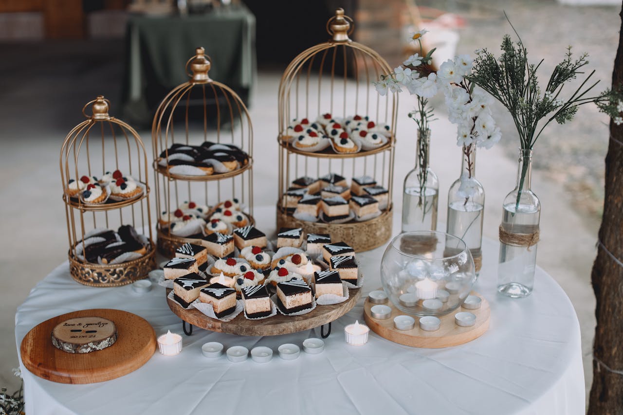 our-story-01 Chic dessert table with birdcage cake displays, sweets, and floral decor for a stylish celebration.